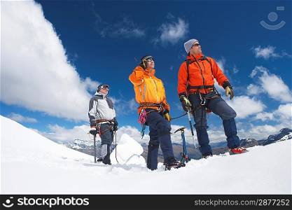 Three mountain climbers on snowy peak