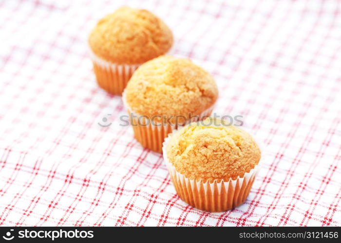 three muffins on plaid fabric