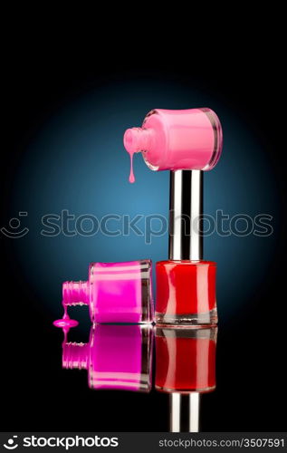 Three nail polish bottles of bright colors with juicy falling drops against black background.