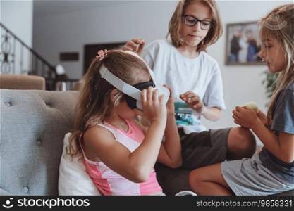 Three nice children enjoying virtual reality games. Happy friends with pleasure spending weekend together at home.. Happy Siblings Playing Video Games