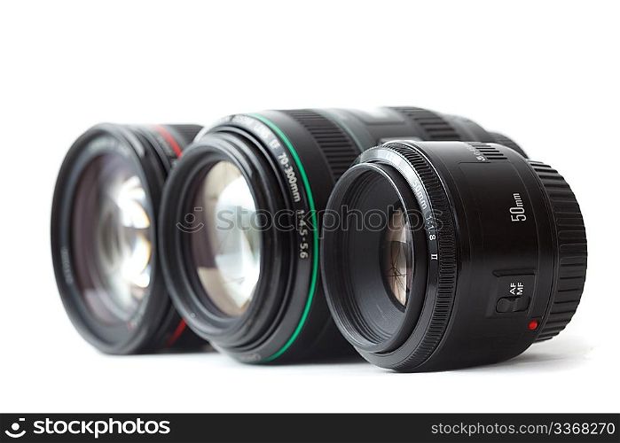 Three of lens to camera put in row. Isolated on white background. Focus on the front lens.
