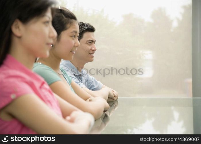 Three office workers sitting in a conference room and smiling