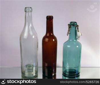 Three old empty bottles isolated on mirror