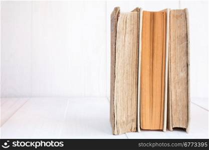 Three old ld books in a row on wooden background