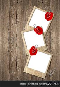 three old photo frames with red hearts petals over rustic wooden background. empty field for your photo or picture