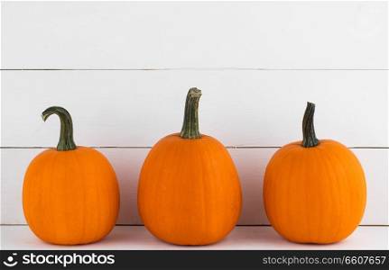 Three orange pumpkins on white wooden background , Halloween concept. Pumpkins on wooden background