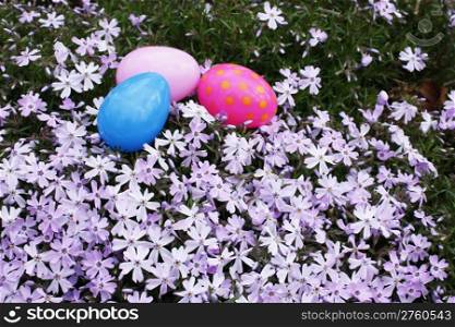 Three pastel colored Easter eggs hidden in the flowering grass