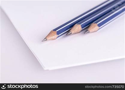 three pencil on white paper