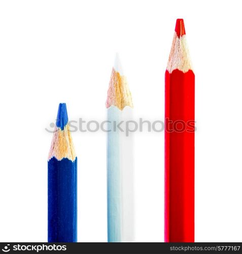 Three pencils each of a different colour, red white and blue, on a blue background.