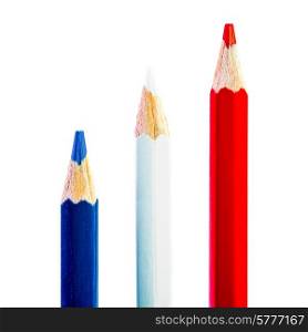Three pencils each of a different colour, red white and blue, on a blue background.