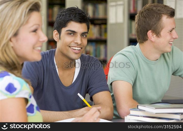 Three people in library studying (selective focus)