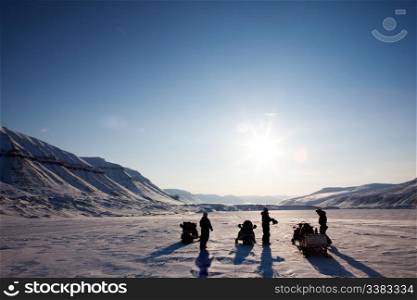 Three people on a winter snowmobile adventure in Svalbard, Norway