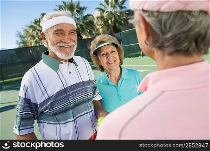 Three people on tennis court