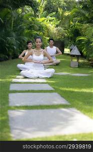 Three people practising yoga together