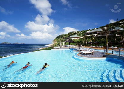 Three people relaxing in a swimming pool of a resort near a seashore, St. Bant&acute;s
