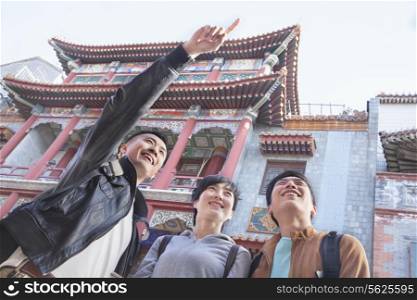 Three people sightseeing, looking and pointing.