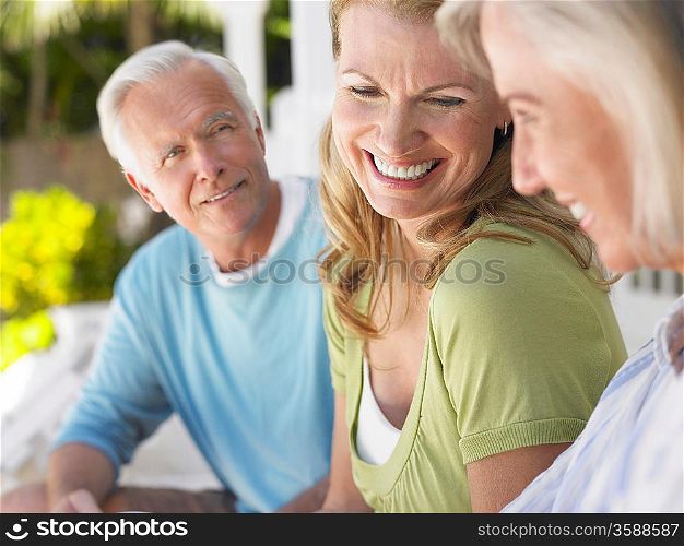 Three people sitting on verandah