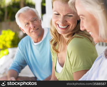 Three people sitting on verandah