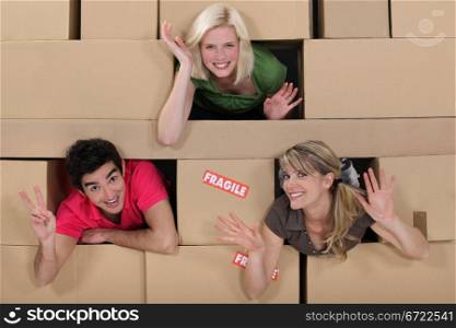Three people surrounded by boxes