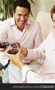 Three people toasting glasses of wine