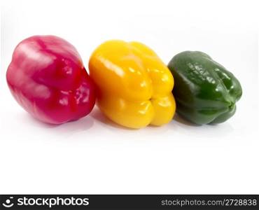 Three peppers of different colors with a white background