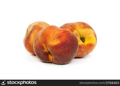 Three perfect, ripe peaches isolated on a white background.