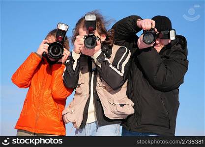 three photographers against blue sky