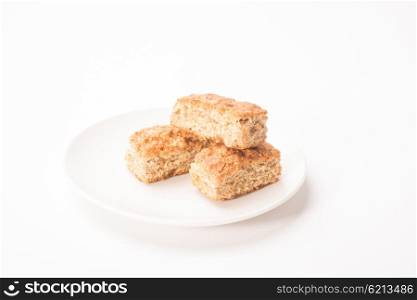 Three pieces of rusks in a stack on a white plate all on an isolated white background.