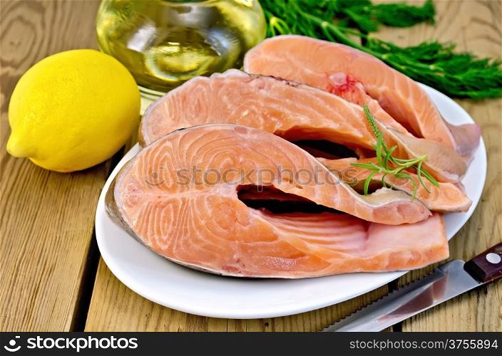 Three pieces of trout in white plate with rosemary, lemon, vegetable oil, dill on a wooden boards background