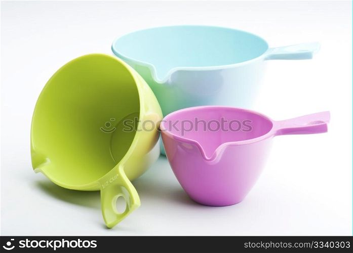 Three Plastic Measuring Cups On A White Background