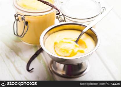 Three pods of vanilla pudding with vanilla sticks. Sweet vanilla pudding dessert
