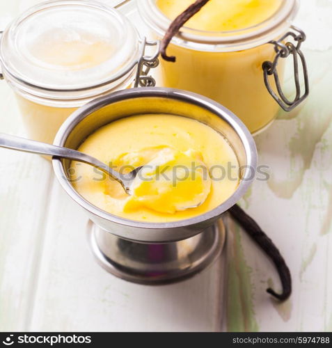 Three pods of vanilla pudding with vanilla sticks. Sweet vanilla pudding dessert