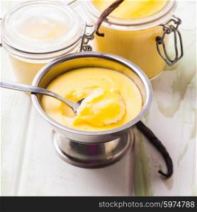 Three pods of vanilla pudding with vanilla sticks. Sweet vanilla pudding dessert