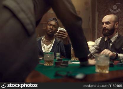 Three poker players in casino, blackjack. Games of chance addiction, gambling house. Men leisures with whiskey and cigars, gaming table with green cloth. Three poker players in casino, blackjack