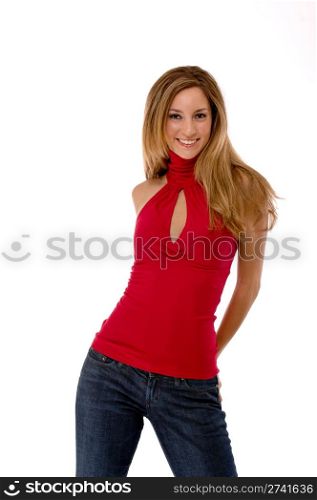 Three quarter length studio shot of a beautiful young woman isolated on white. Her body is facing the camera and she is smiling. She is wearing a red shirt and jeans.