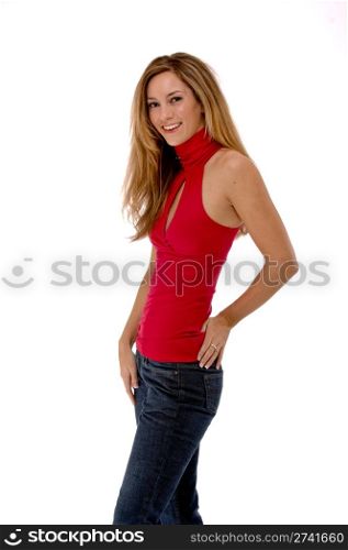Three quarter length studio shot of a beautiful young woman isolated on white. She is smiling and wearing a red shirt and jeans.