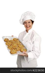 Three quarter view of a happy, smiling bakery chef holding a tray of fresh chocolate chip cookies. Isolated on white.