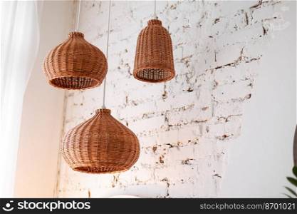 three rattan chandeliers different forms on white brick wall background. Straw l&shade in cozy living room. Eco-friendly interior design using natural materials. Scandinavian interior. copy space.. three rattan chandeliers different forms on white brick wall background. Straw l&shade in cozy living room. Eco-friendly interior design using natural materials. Scandinavian interior. copy space