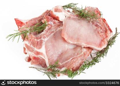 three raw pork steaks with rosemary isolated on white