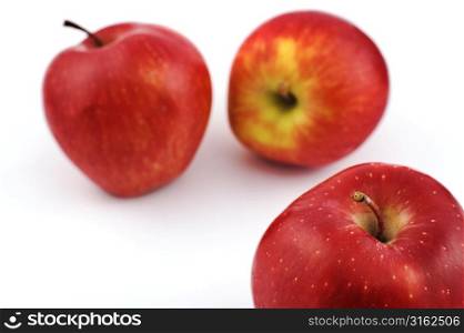 Three red apples on white