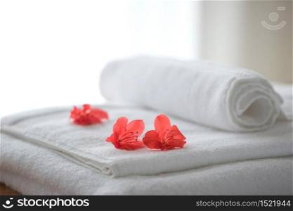 Three red azalead flowers on folded towels and backlight