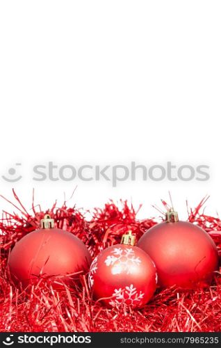 three red Christmas balls and tinsel isolated on white background