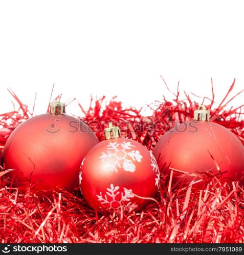 three red Christmas baubles and tinsel isolated on white background
