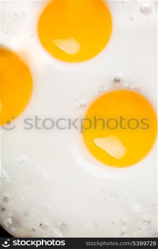 three ried eggs closeup background
