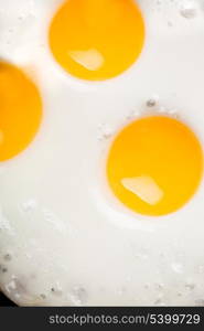 three ried eggs closeup background