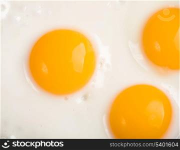 three ried eggs closeup background