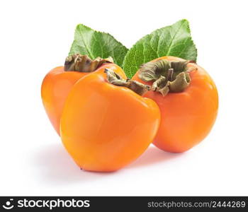 Three ripe juicy sweet persimmons with green leaves isolated on white background. Three ripe juicy sweet persimmons with green leaves isolated on white