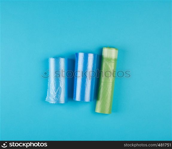 three rolled up rolls with plastic garbage bags on a blue background