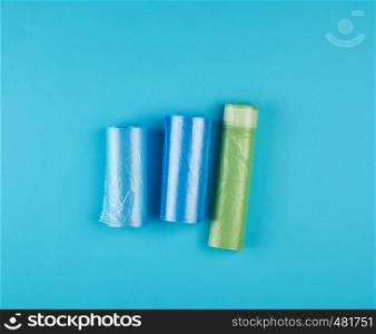 three rolled up rolls with plastic garbage bags on a blue background