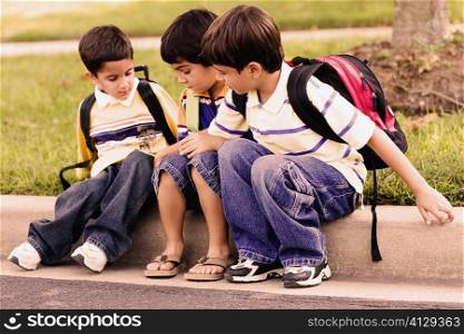 Three schoolboys sitting together